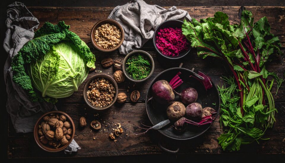 Fränkische Zutaten auf rustikalem Holztisch – Wirsing, Rote Bete, Walnüsse, Grünkern und frische Kräuter als Symbol für vegane, regionale Küche in Fürth.