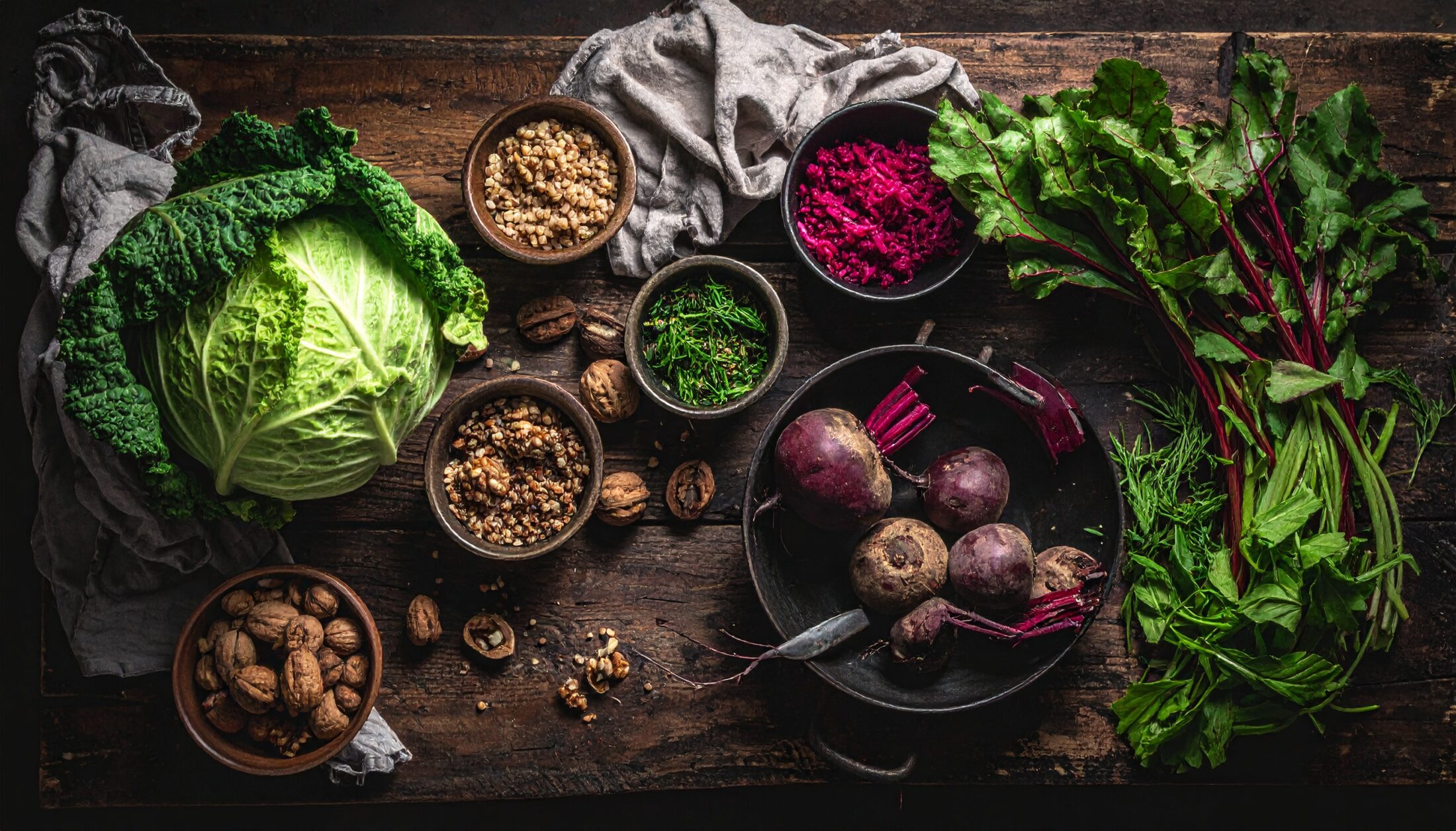 Fränkische Zutaten auf rustikalem Holztisch – Wirsing, Rote Bete, Walnüsse, Grünkern und frische Kräuter als Symbol für vegane, regionale Küche in Fürth.